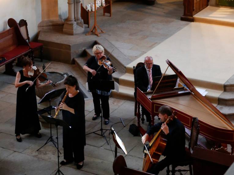 Musikerinnen und Musiker spielen in einem Kloster.