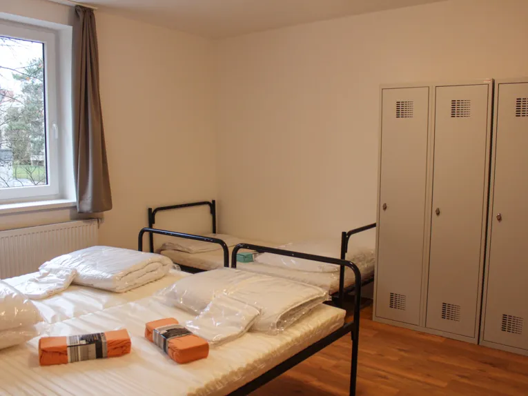 Ein Schlafzimmer mit drei Betten und drei Schränken.