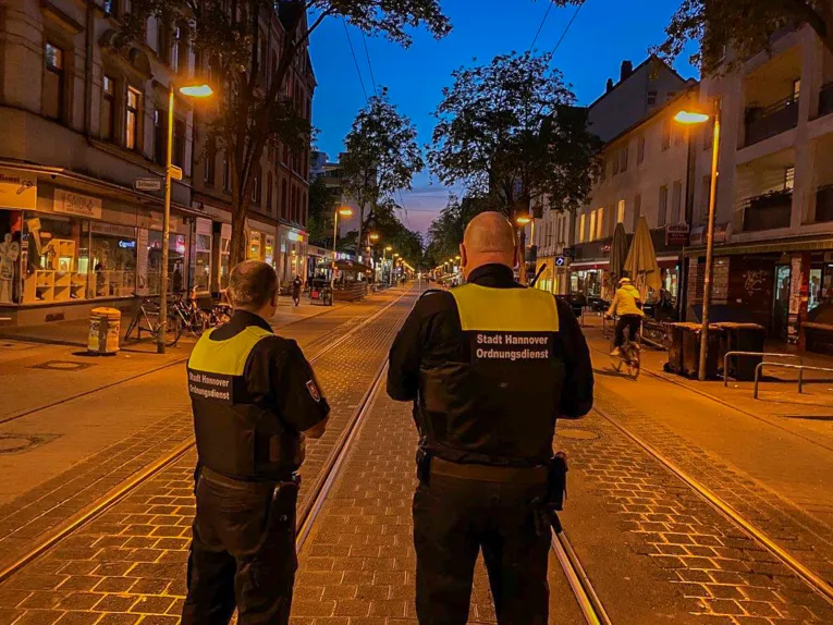 Zwei Männer auf einer langen Straße.