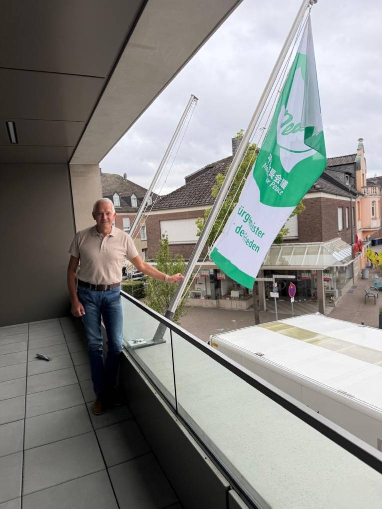 Bürgermeister Wilhelm Sendermann vor der Flagge am neuen Olfener Rathaus.