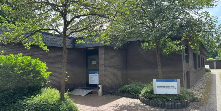 Vor dem Eingang eines Gebäudes ist ein Schild mit den Worten "Beratungsstelle für Eltern, Kinder und Jugendliche (BEKJ) Ronnenberg.