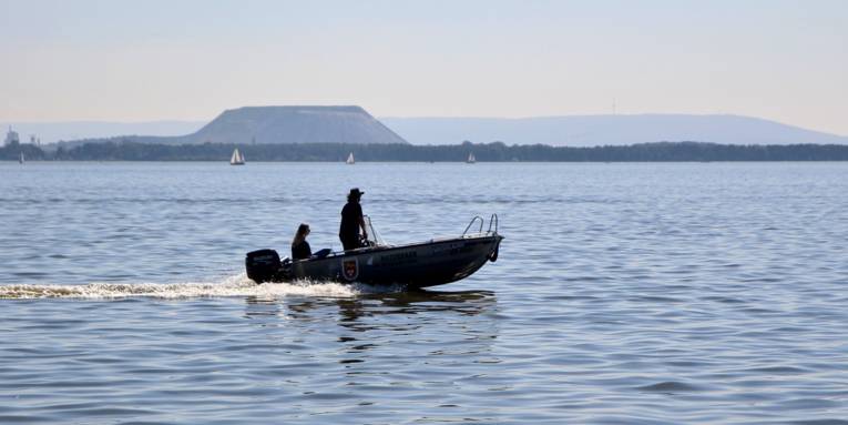 Zwei Personen fahren mit einem kleinen Motorboot über das Steinhuder Meer.
