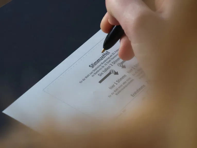 Stimmzettel mit Wähler*in im Anschnitt