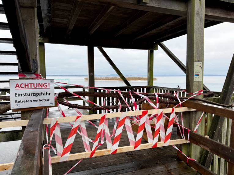 Rot-weißes Absperrband und Holzlatten versperren den Zugang zu einer Aussichtsplattform. Daneben ist ein Schild mit dem Text "Achtung! | Einsturzgefahr | Betreten verboten!"