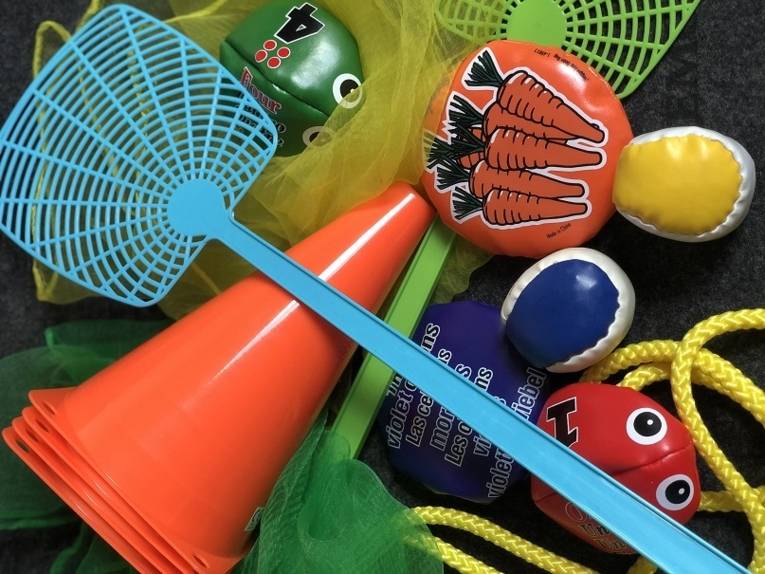 Verkehrshütchen, Jonglierbälle und andere Sportgeräte liegen auf einem haufen.