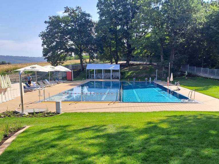 Freibad bei Sonnenschein, Rasen im Vordergrund, bei Sonnenschein