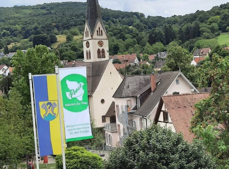 Die Hissung der Flagge der Mayors for Peace vor dem Ebringer Rathaus