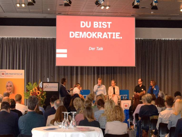 Eine Podiumsdiskussion mit 6 Personen vor Publikum