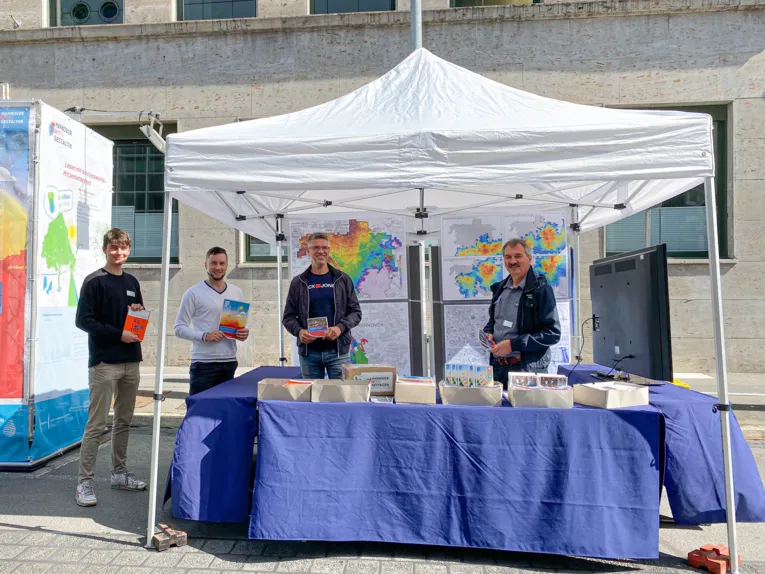 Vier Personen an einem Infostand.