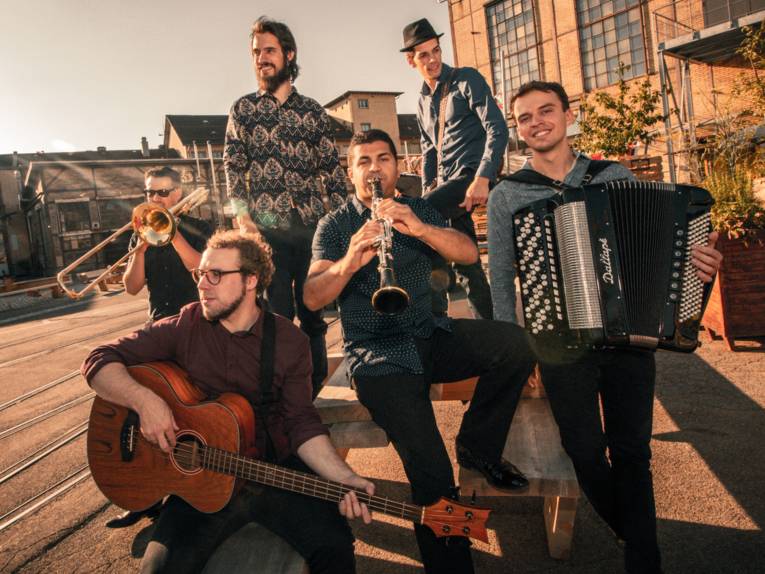 Pressebild von Musikern. Sie haben ihre Musikinstrumente bei sich.