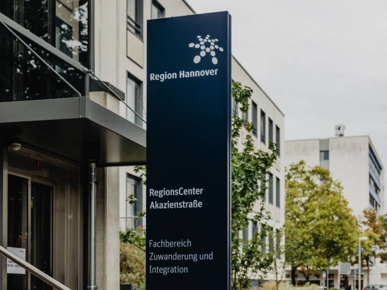 Schild an einem Eingang auf dem "Regionscenter Akazienstraße - Fachbereich Zuwanderung und Integration" steht.