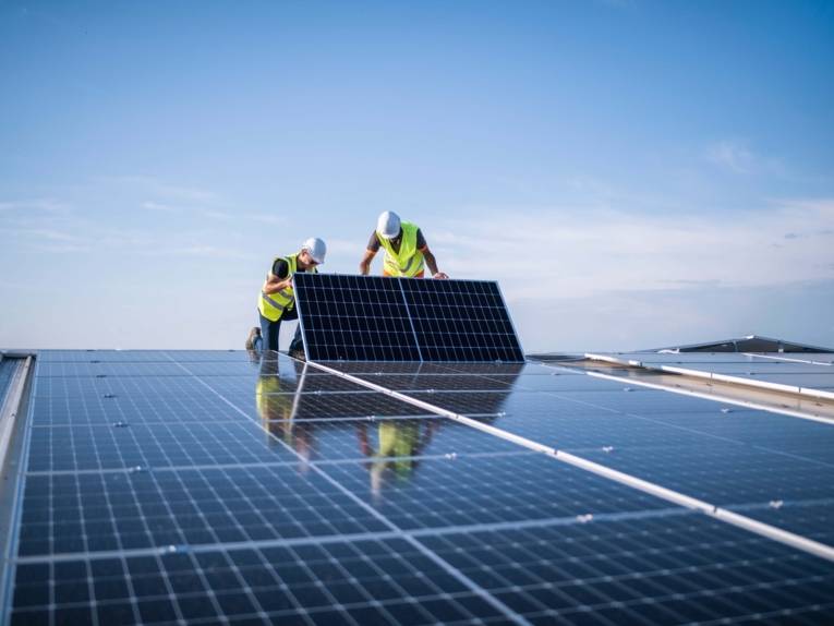 Eine Solaranlage, die von zwei Menschen montiert werden.