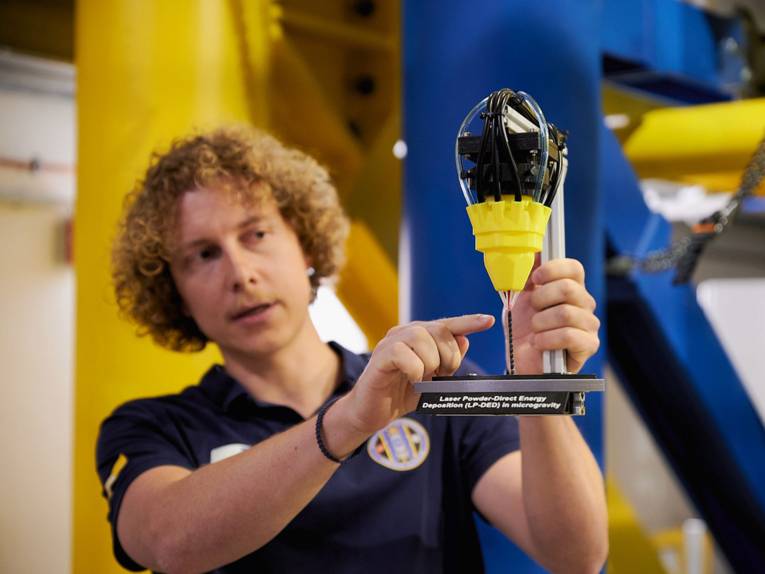 Ein Forscher hält ein Objekt in den Händen.