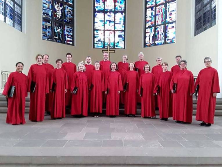 Menschengruppe in roten Roben in einer Kirche.