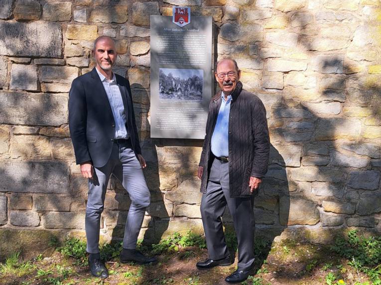 Zwei Männer auf einem Friedhof.