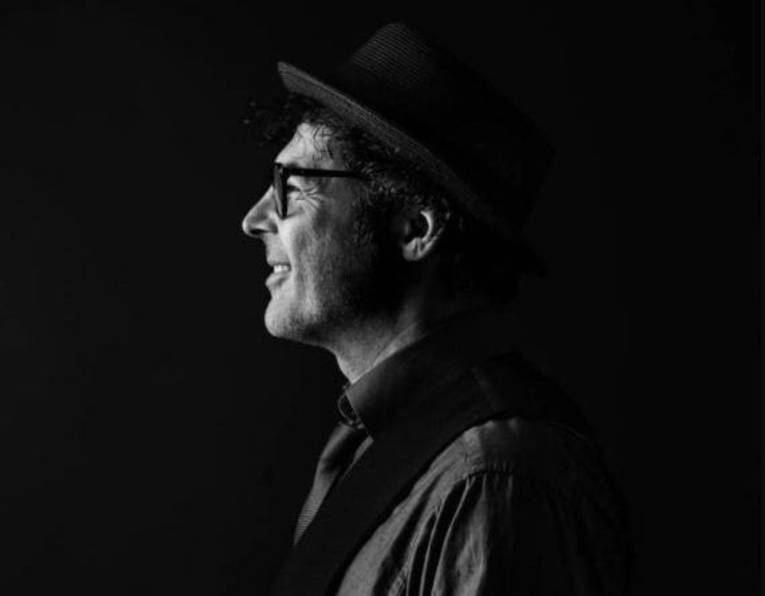 Profilbild eines lächelnden Mannes mit Brille, Bart und Hut