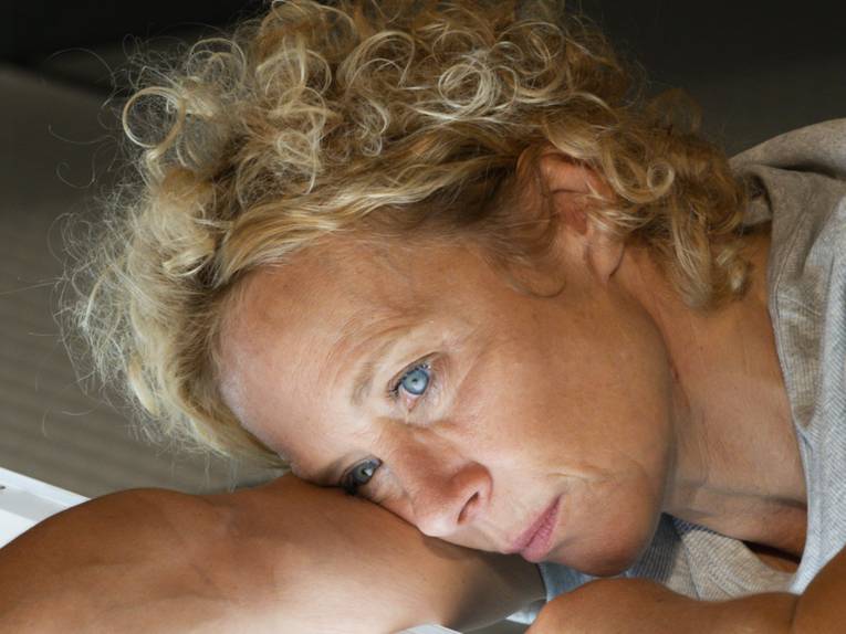 Porträtaufnahme von Katja Riemann, die ihren Kopf an ihren Arm lehnt.