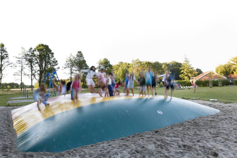 Kinder springen auf einem Hüpfkissen