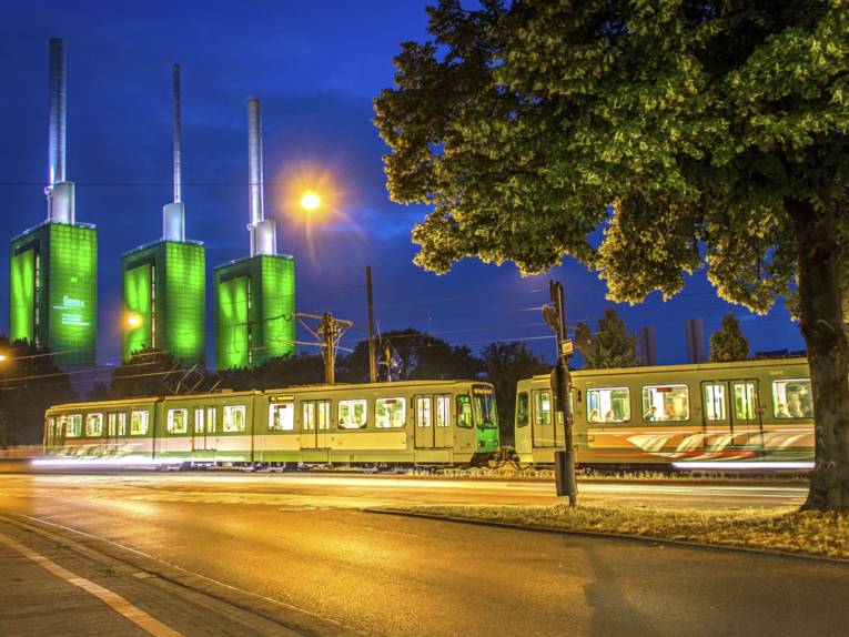 Ein Zweiwagenzug von TW 6000ern der Linie 10 Richtung Hauptbahnhof auf der Brücke der Spinnereistraße. Im Hintergrund die drei Schornsteine des Heizkraftwerks von enercity in Linden.
