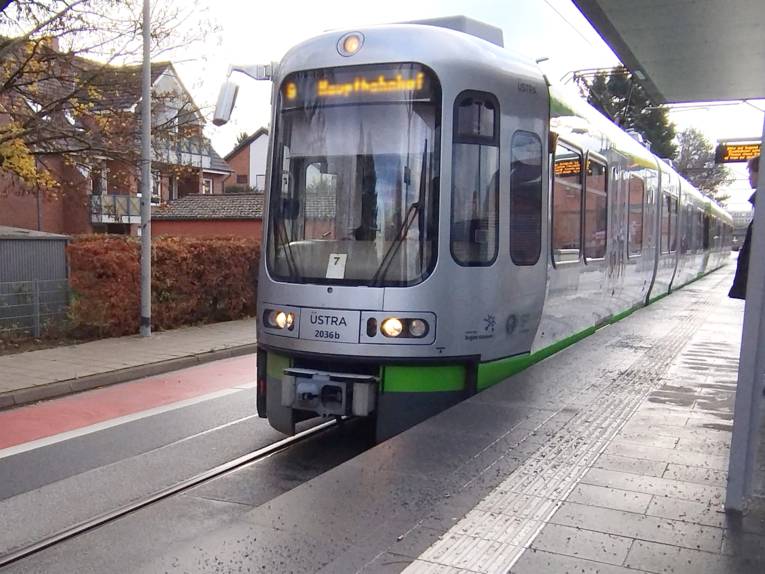 Auf einem Hochbahnsteig fährt eine Stadtbahn der Üstra ein.