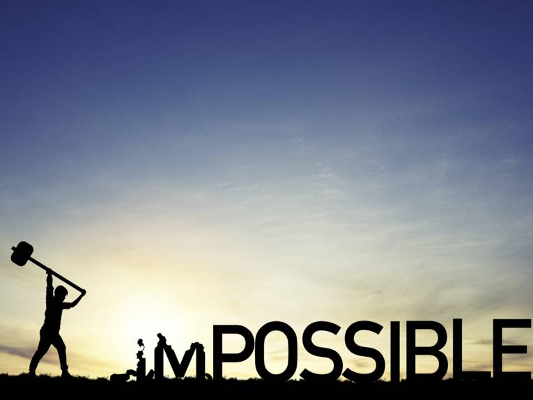 Sihouette eines Mannes, der mit einem großen Vorschlaghammer ausholt. Vor ihm ist der Schriftzug "IMPOSSIBLE", von dem er die ersten beiden Buchstaben zerschlägt.