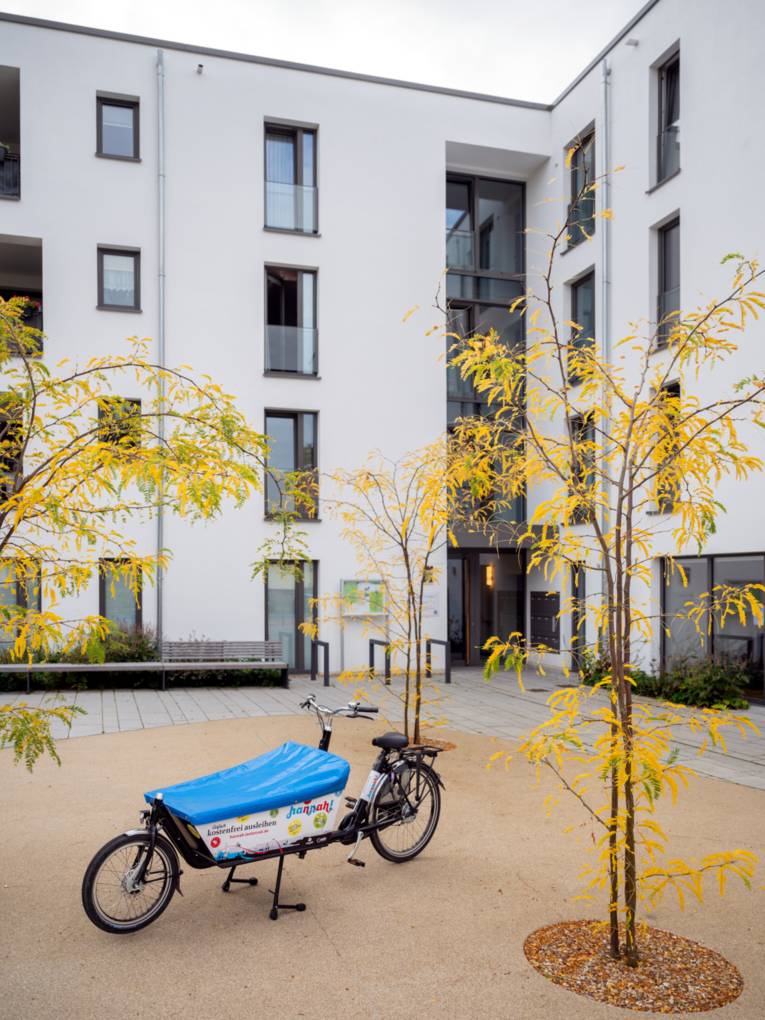 Ein Lastenrad steht vor einem modernen Gebäude.
