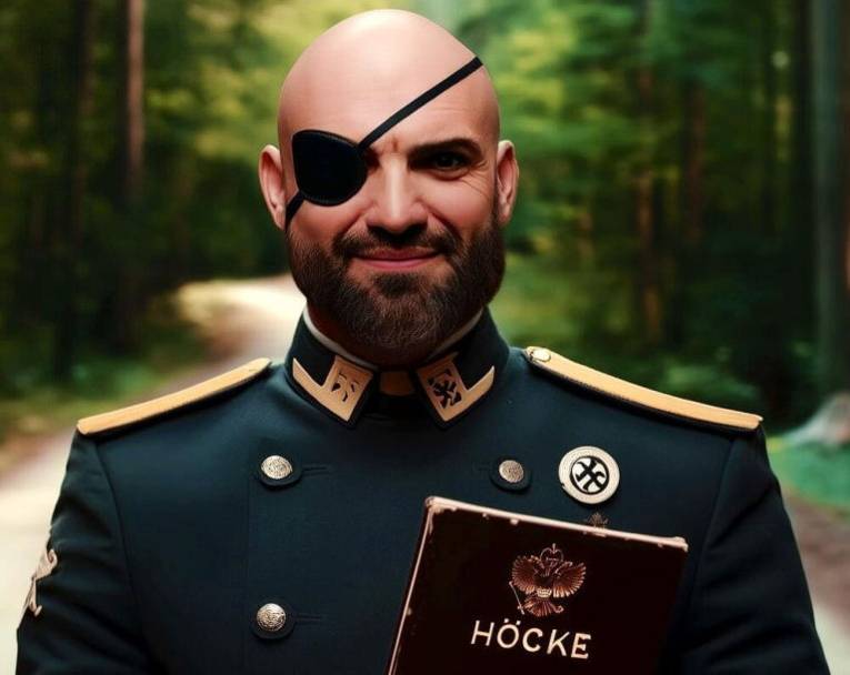 Mann mit Glatze, Vollbart und Augenklappe in einer Uniform mit goldenen Epauletten hält ein Buch mit der Aufschrift Höcke.