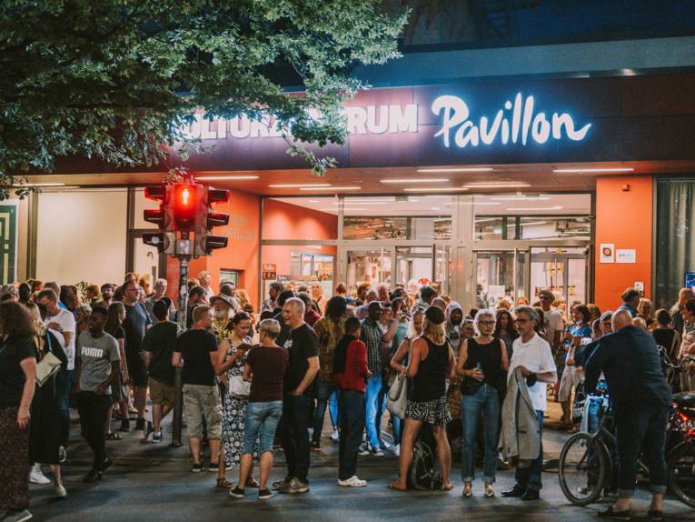 Eine Menschenmenge steht abends vor dem Eingang des Kulturzentrums Pavillon.
