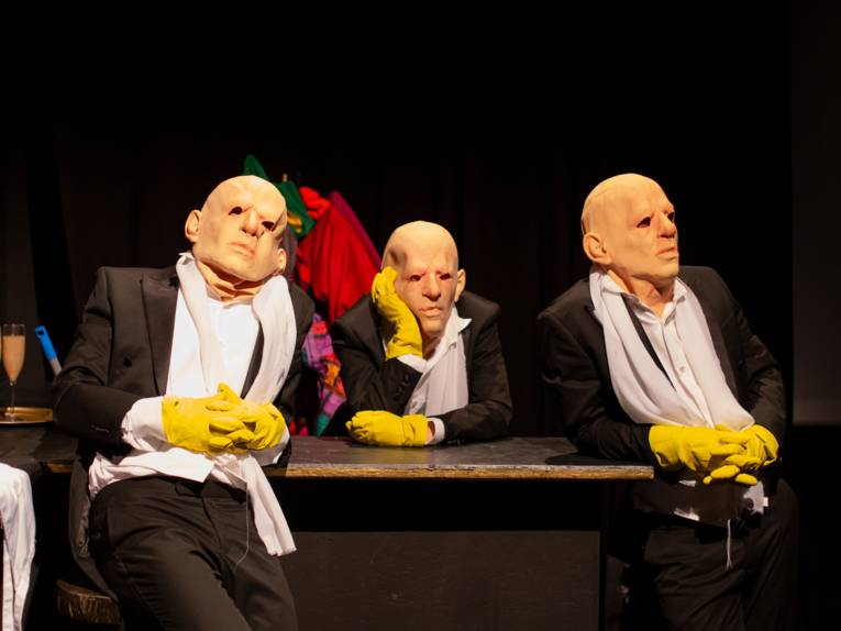 Drei Personen mit Masken