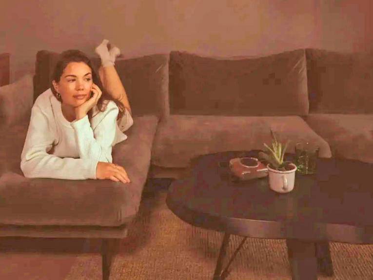 Eine Frau liegt auf einem Sofa.