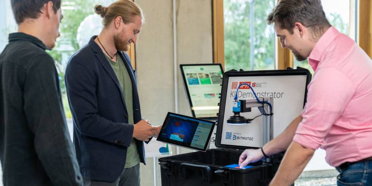 Drei Männer vor einem Bildschirm