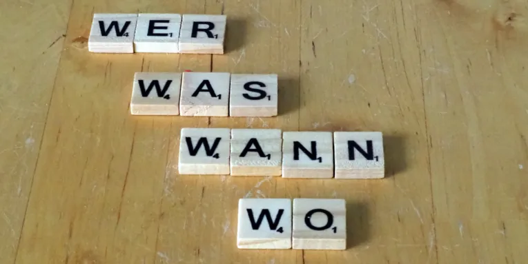 Buchstabenplättchen bilden die W-Fragen Wer, was wann und wo.
