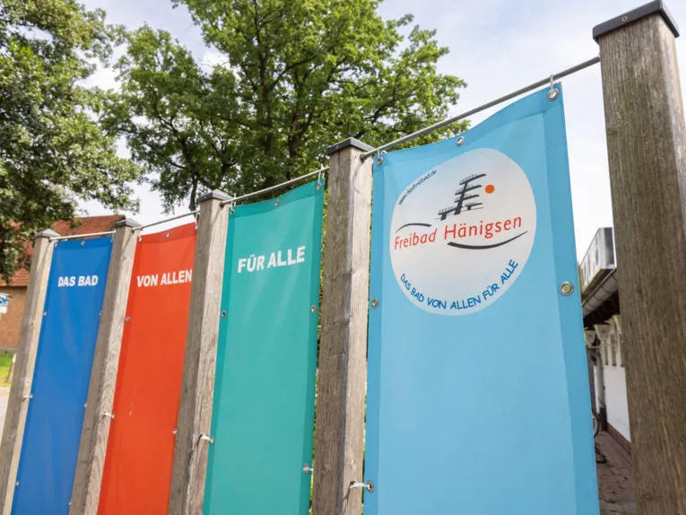 Vier Banner, auf denen der zusammengesetzte Schriftzug "Das Bad von allen f&uuml;r alle Freibad H&auml;nigsen" zu lesen ist