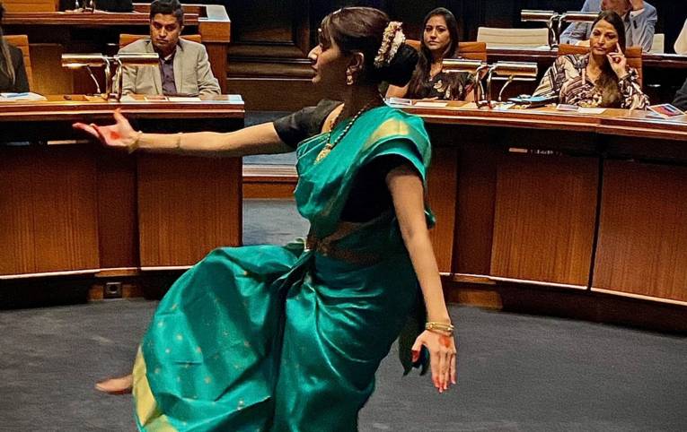 Eine Frau tanzt in einem indischen Kleidungsstück, einem Sari, im Hodlersaal des Neuen Rathauses in Hannover.