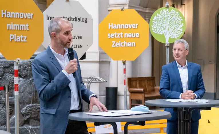 Zwei Männer an Tischen.