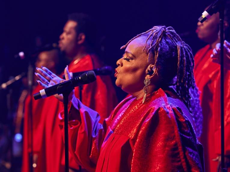 Zu sehen sind Schwarze Gospel-Sängerinnen und -Sänger der Gruppe „The Harlem Gospel Singers“.