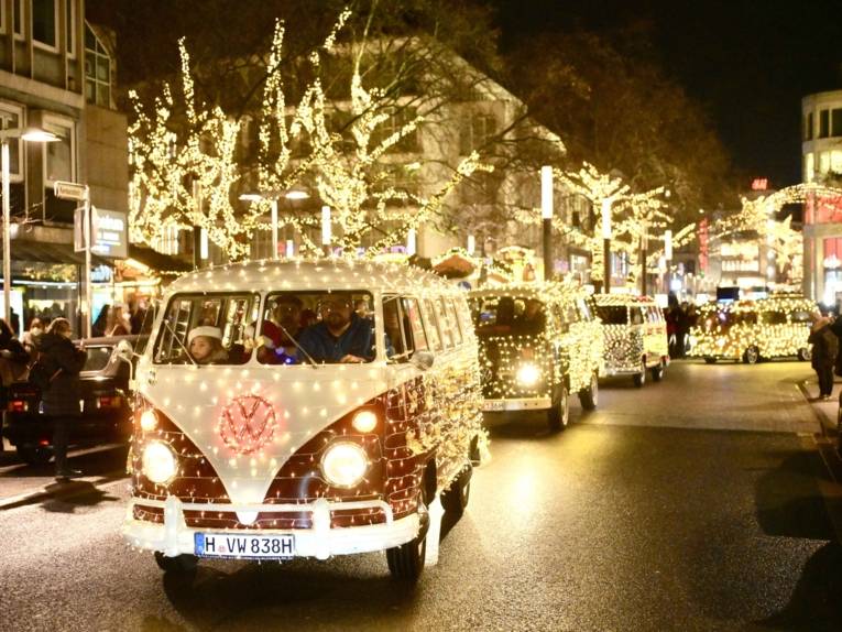 Mit Lichterketten beleuchtete VW-Bullis fahren durch Hannovers Innenstadt