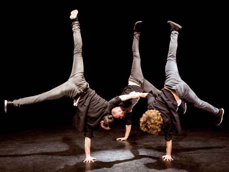 Drei Künstler vom Tridiculous ABC machen einen Handstand auf der Bühne
