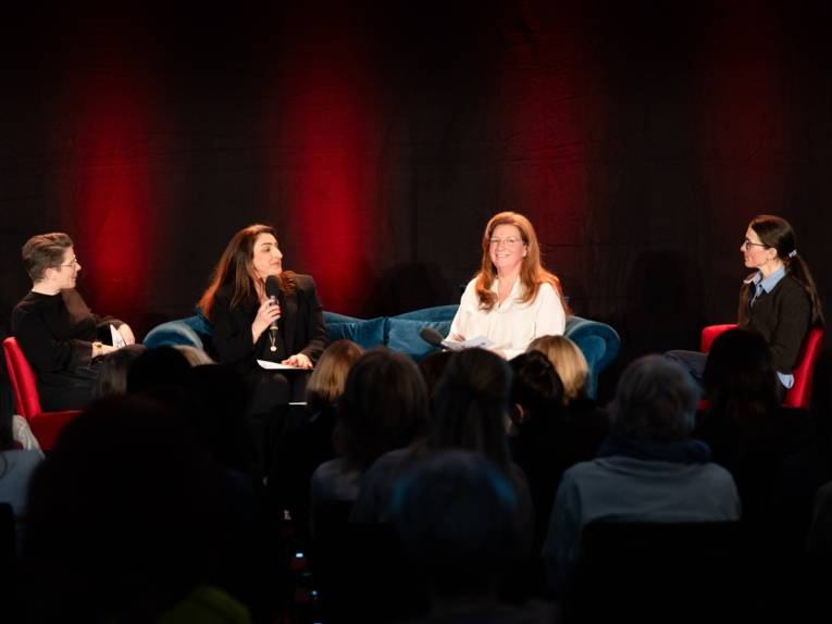 Vier Frauen sitzen auf einer Bühne bei einem Podiumsgespräch