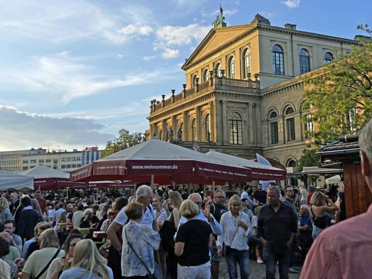 Menschen an Weinständen vor der Oper Hannover
