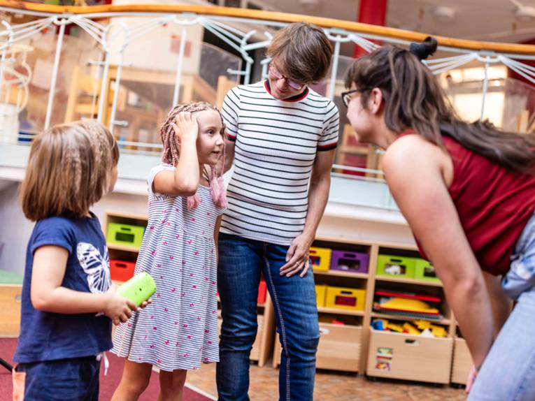 Zwei Frauen mit zwei Mädchen in einem Schulgebäude.