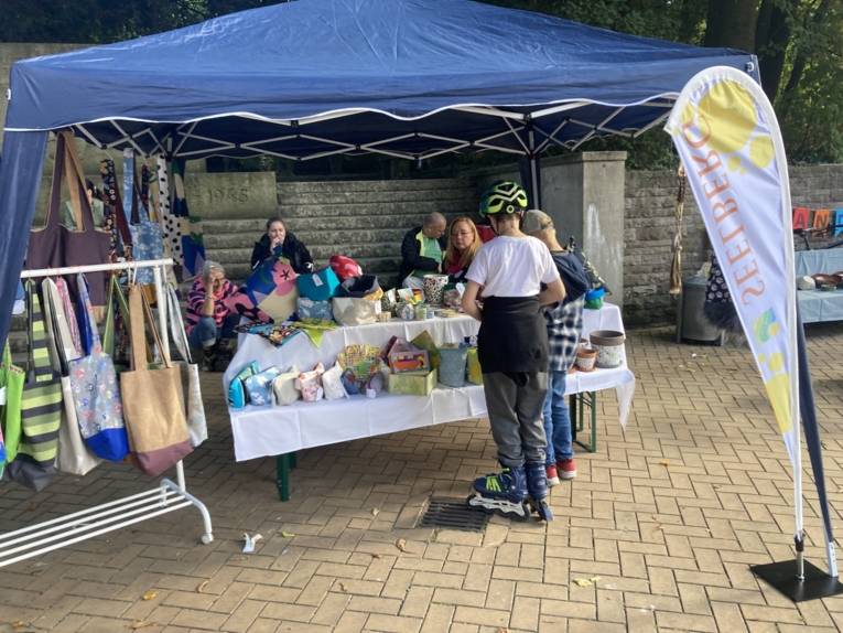 Zwei Kinder schauen sich die selbstgemachten Produkte der Tagesst&auml;tte Resonanz an. Bunte Taschen und selbstgen&auml;hte Beutel
