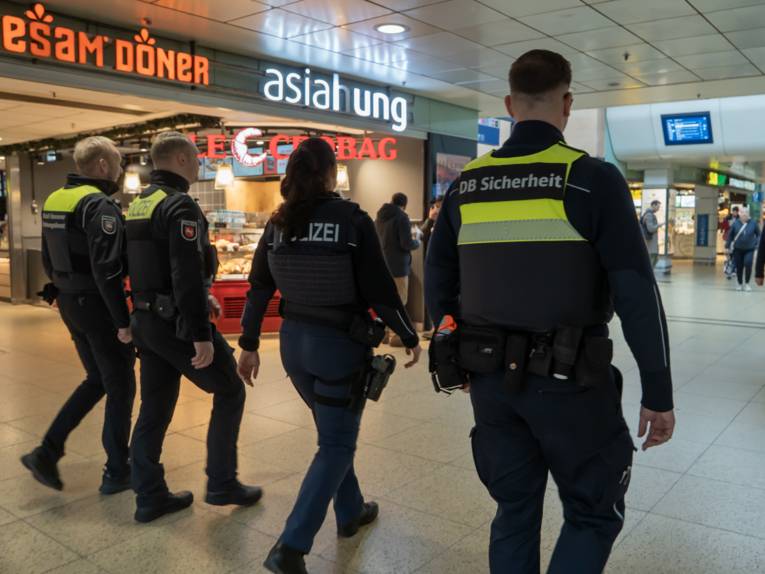 Vier uniformierte Personen in einem Bahnhof.