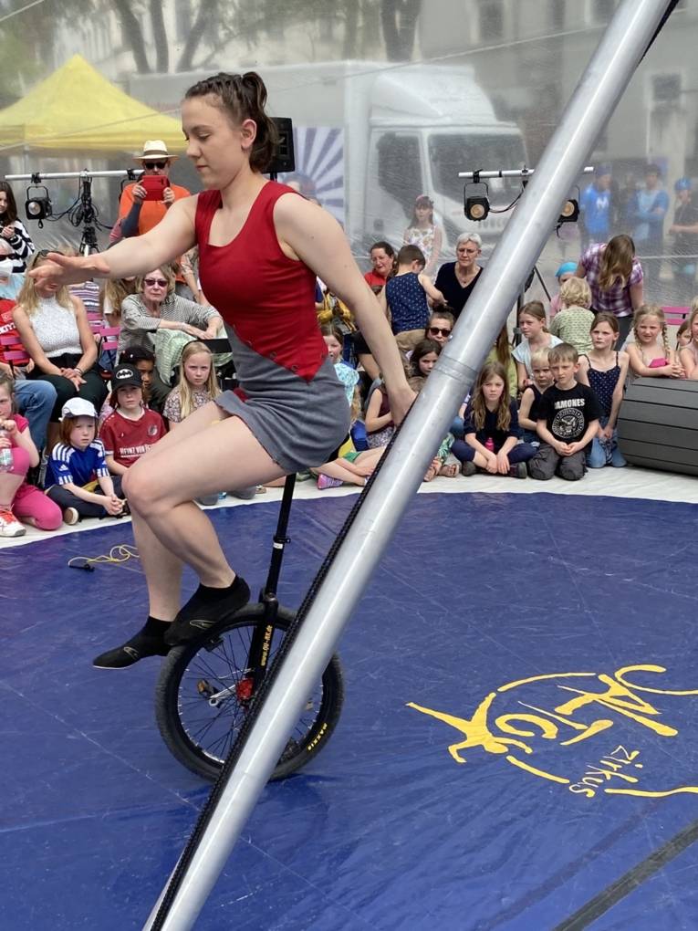 Eine Einradfahrerin macht Kunststücke in der Manage.