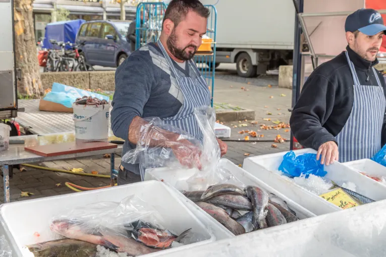 Zwei Fischverk&auml;ufer an einem Marktstand.
