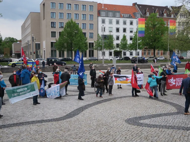 Menschen halten Flaggen und Banner vor dem Neuen Rathaus in Hannover