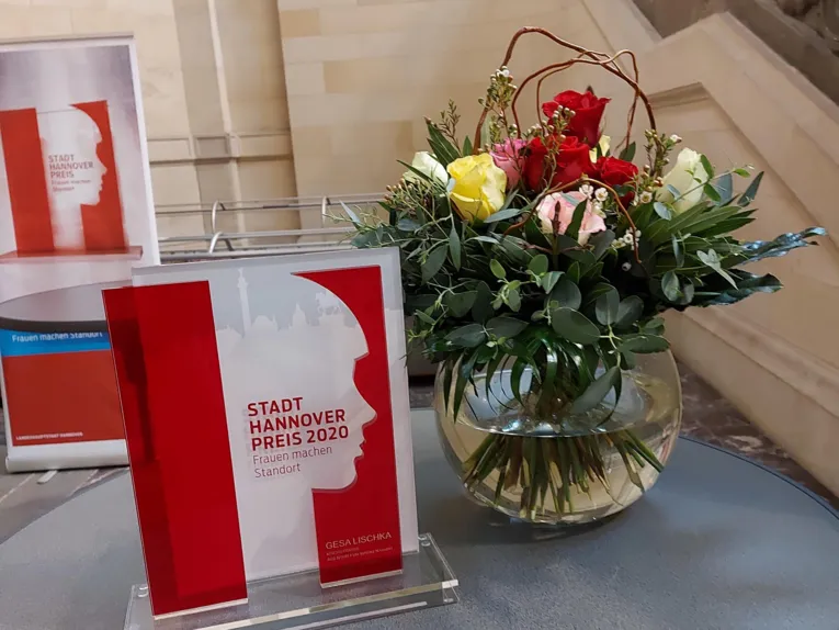 Der STADT-HANNOVER-PREIS neben einer Vase mit Blumen.