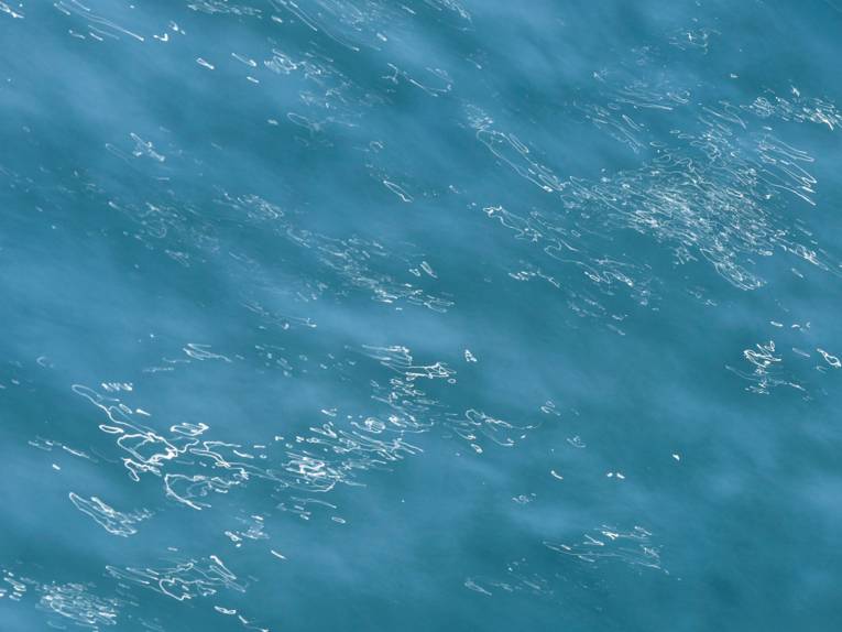 Blick auf eine blaue, leicht wellige Wasserfläche.