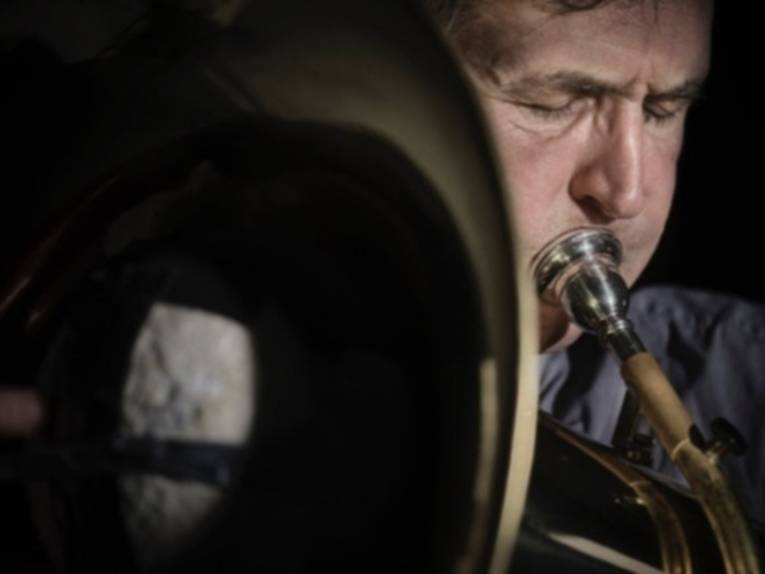 Ein Mann, der in seine Tuba bläßt.