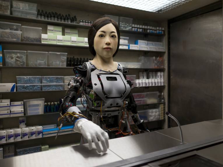 Weiblicher Roboter hinter einer Kiosktheke